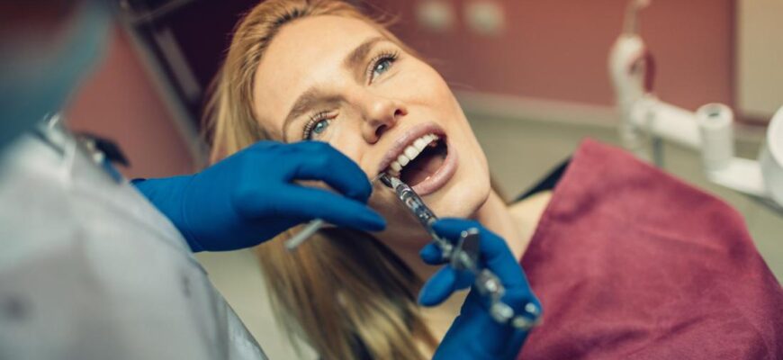 woman-receieving-novocaine-anesthesia-from-dentist-during-operation